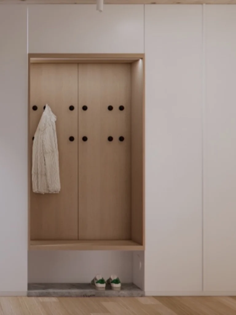 Minimalističen vhodni prostor z vgrajeno garderobo, lesenimi detajli in mehko indirektno osvetlitvijo.
