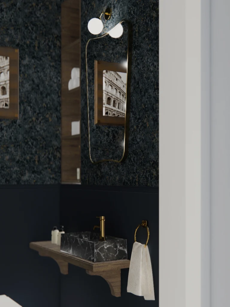 Elegantni gostinski WC z marmornim umivalnikom, temno modrimi stenami, ogledalom z medeninastim okvirjem in dekorativno stensko svetilko.
